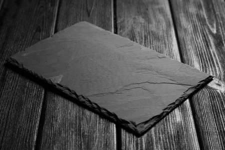 Black slateboard on dark wood background