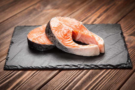 Fresh salmon slice on old woodの写真素材