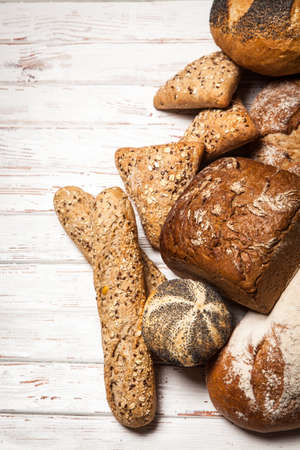 Freshly baked bread assortment on wooden surfaceの写真素材