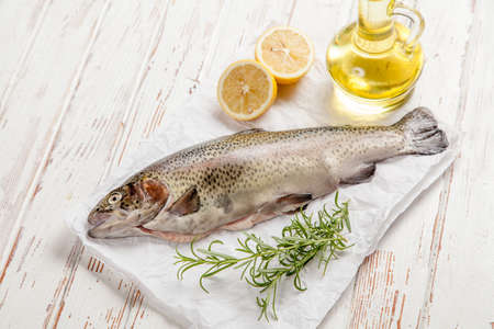 Fresh whole trout on white wood