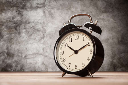 Vintage alarm clock close-up on wooden surfaceの写真素材