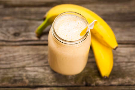 Banana milkshake on wooden tableの写真素材