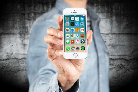 WROCLAW, POLAND - APRIL 12, 2016: Apple iPhone SE smartphone with main menu on screen