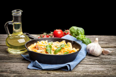 Traditional penne pasta in cast iron skilletの写真素材