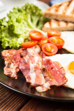 Traditional bacon and eggs breakfast on a plateの写真素材
