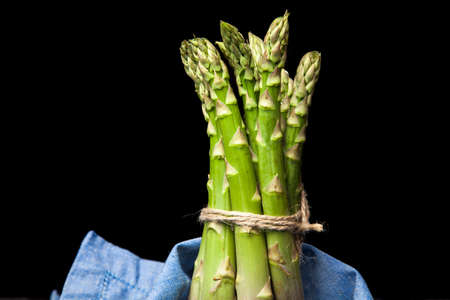 Bunch of fresh asparagus on dark backgroundの写真素材