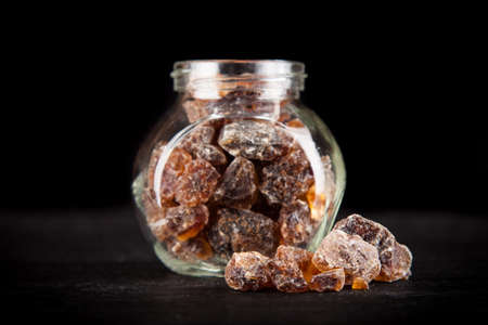 Brown unrefined sugar on black backoundの写真素材