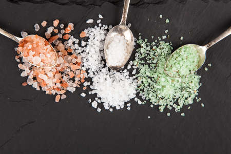 Different types of cooking salt on dark slate backgroundの写真素材