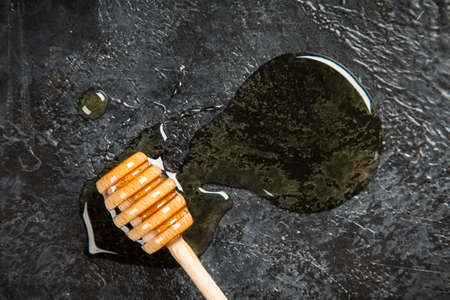 Honey dipper on black backgroundの写真素材
