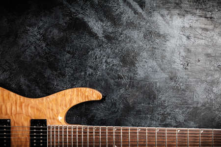 Electric guitar with natural wood finish on grey backgroundの写真素材