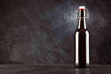 Beer bottle on dark background, studio photoの写真素材