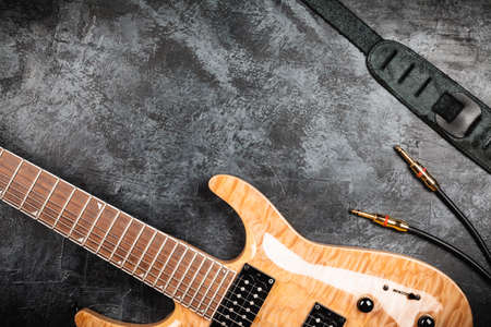 Electric guitar with natural wood finish on grey backgroundの写真素材