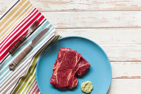 Raw steak on a blue plateの写真素材