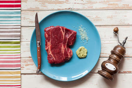 Raw steak on a blue plateの写真素材