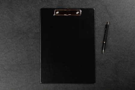 Black clipboard on leather surface tableの写真素材