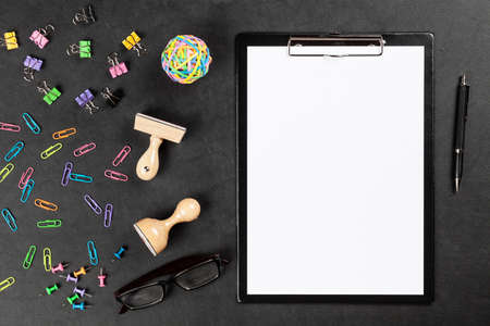 Black clipboard and office supplies on leather surface tableの写真素材