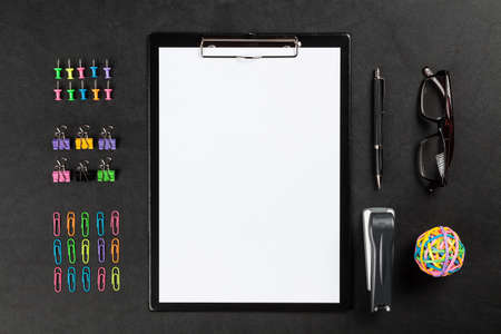 Black clipboard and office supplies on leather surface tableの写真素材