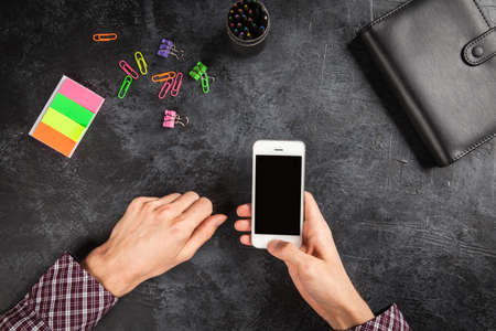 Male hands holding a smartphoneの写真素材