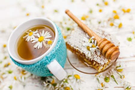 Honeycomb and chamomile tea on whiteの写真素材