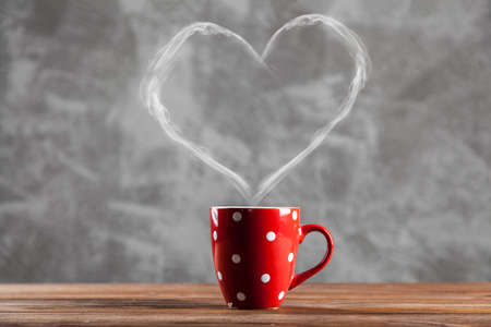 Cup of coffee with a heart shaped steamの写真素材