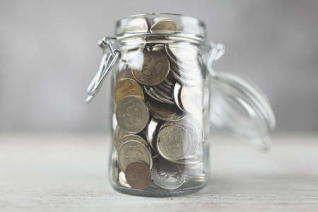 Coins in a glass jarの写真素材