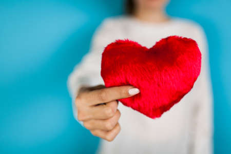 Female hands holding a red heartの写真素材