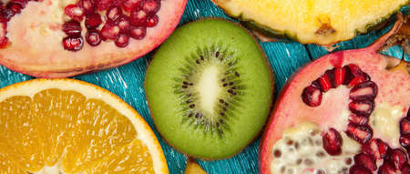 Colorful fruit slices on blue wood surfaceの写真素材