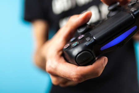 Male hands holding a PS4 controllerのeditorial素材