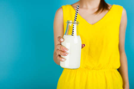 Woman holding a bottle of milkの写真素材