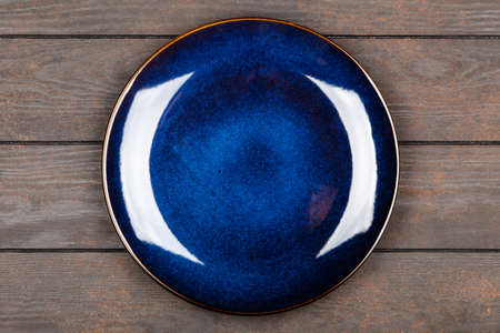 Blue plate on brown wooden tableの写真素材