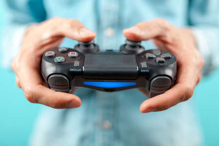 Male hands holding a PS4 controllerのeditorial素材