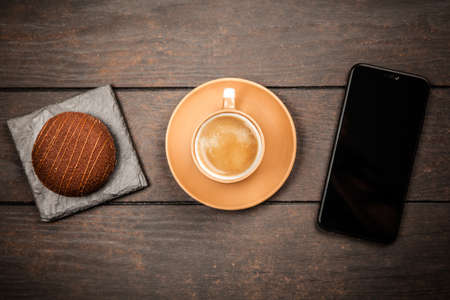 Coffee, dessert and a smartphone