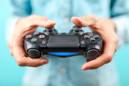 Male hands holding a PS4 controllerのeditorial素材