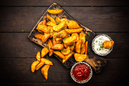 Baked potato fries on wooden tableの写真素材