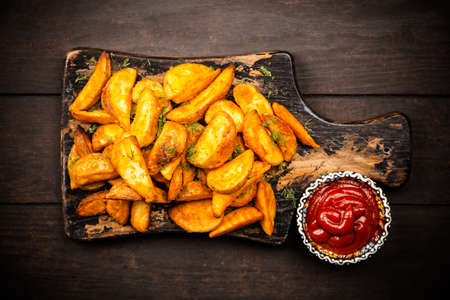 Baked potato fries on wooden table