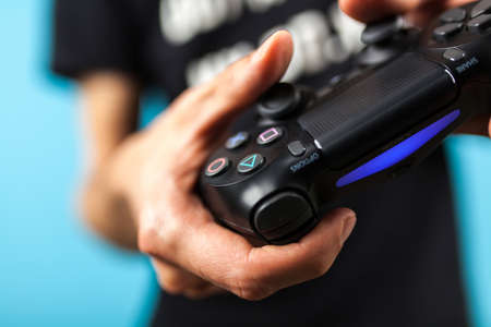 Male hands holding a PS4 controllerのeditorial素材