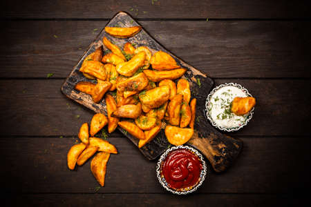 Baked potato fries on wooden table