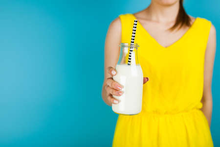 Woman holding a bottle of milkの写真素材