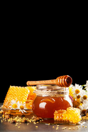 Honey jar and dipper with leaking honeyの写真素材
