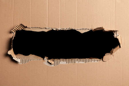 Cardboard with a hole - black backgroundの写真素材