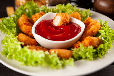 Crispy chicken nuggets with lettuce and ketchupの写真素材