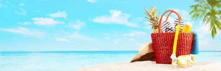 Red beach bag on blue beach and sky backgroundの写真素材