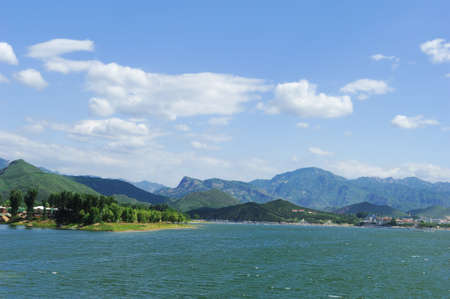 View of lake and mountains, blue sky and white cloudsの写真素材