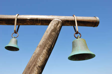 two bells hanging on wooden rackの写真素材