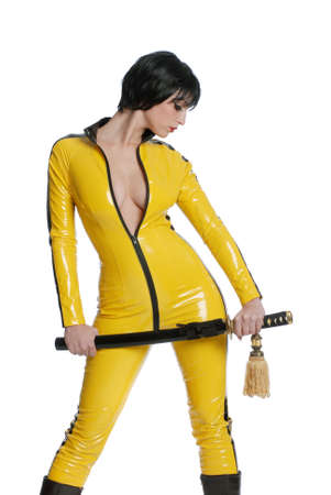 Beautiful woman in yellow latex jump suit with samurai swordの写真素材
