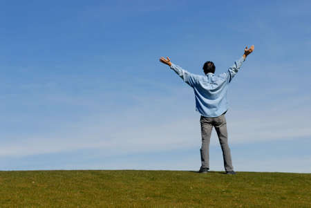 Man with arms raised up to sky