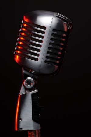 Vintage microphone on black with red highlightsの写真素材
