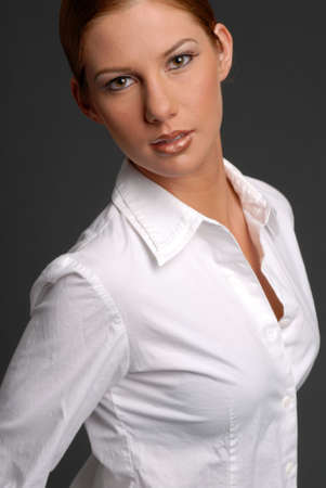 Beautiful woman in white shirt with hair pulled backの写真素材