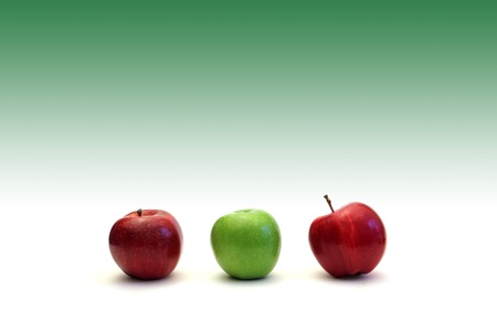 Three apples on a white and green gradient backgroundの写真素材