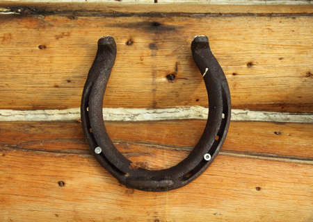 closeup of an iron horseshoe on a wood wallの写真素材